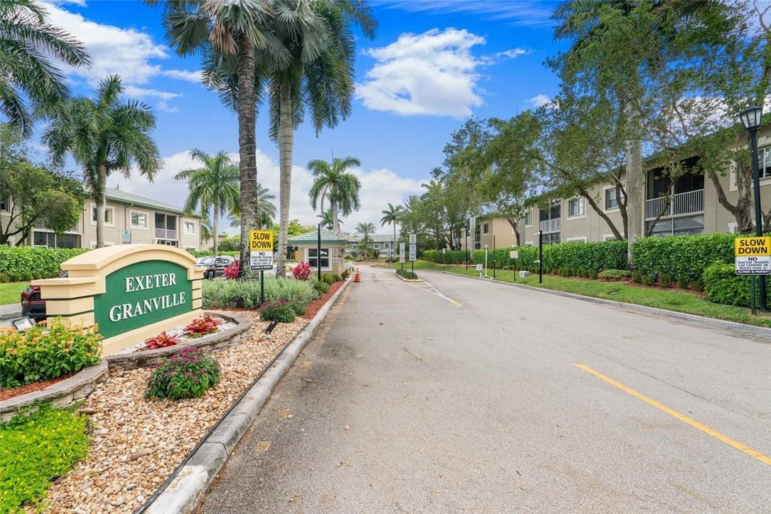 7847 Exeter Boulevard East, Unit 203 Tamarac, FL 33321 - Photo 35 of 36 a city street lined with buildings and trees