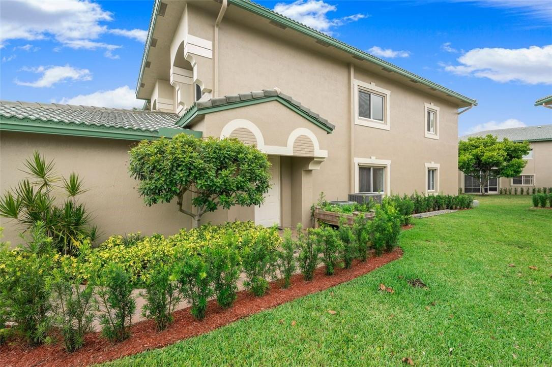 7847 Exeter Boulevard East, Unit 203 Tamarac, FL 33321 - Photo 4 of 36 a front view of a house with garden