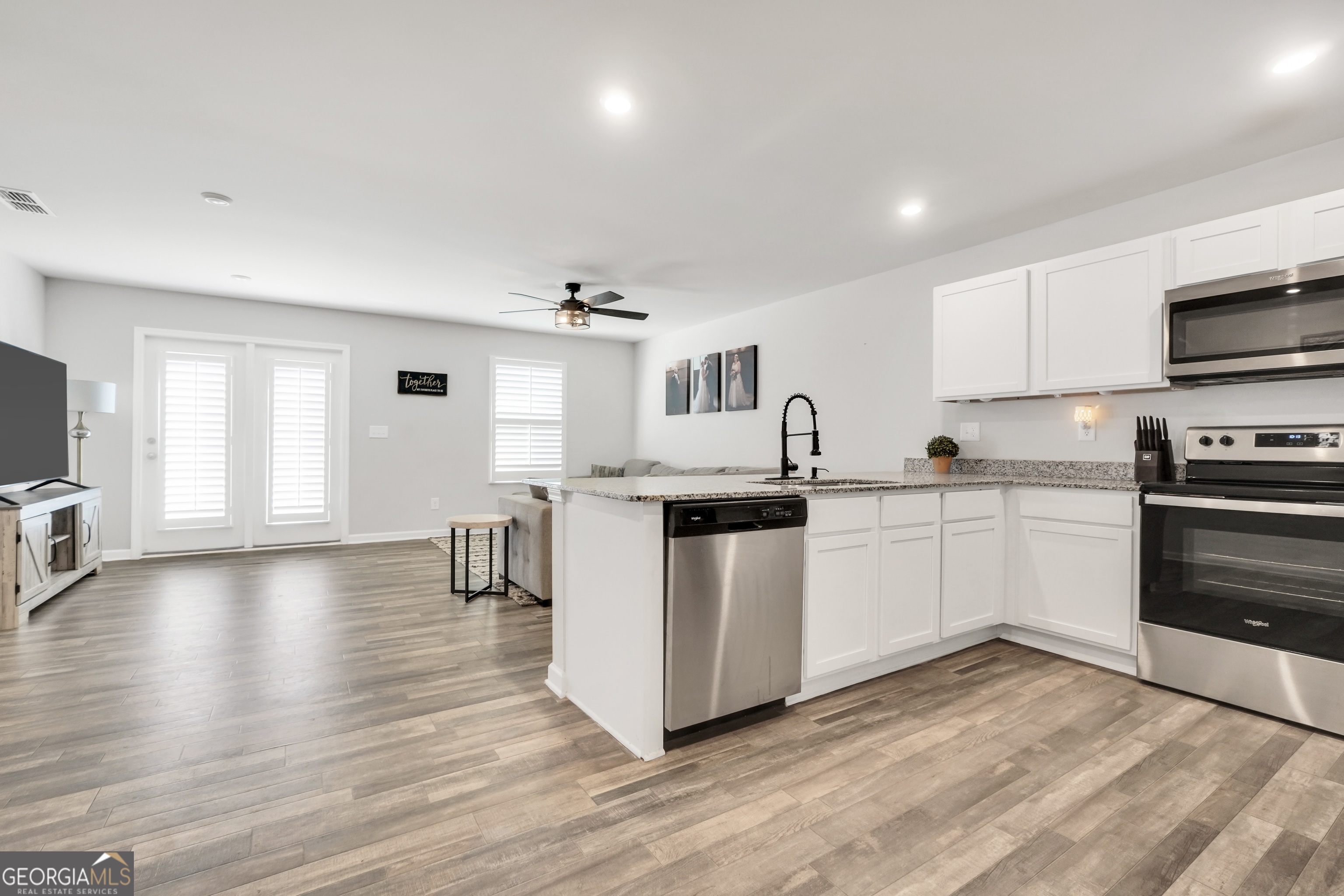 140 Catalpa Road Milner, GA 30257 - Photo 11 of 32 a kitchen with kitchen island white cabinets and stainless steel appliances