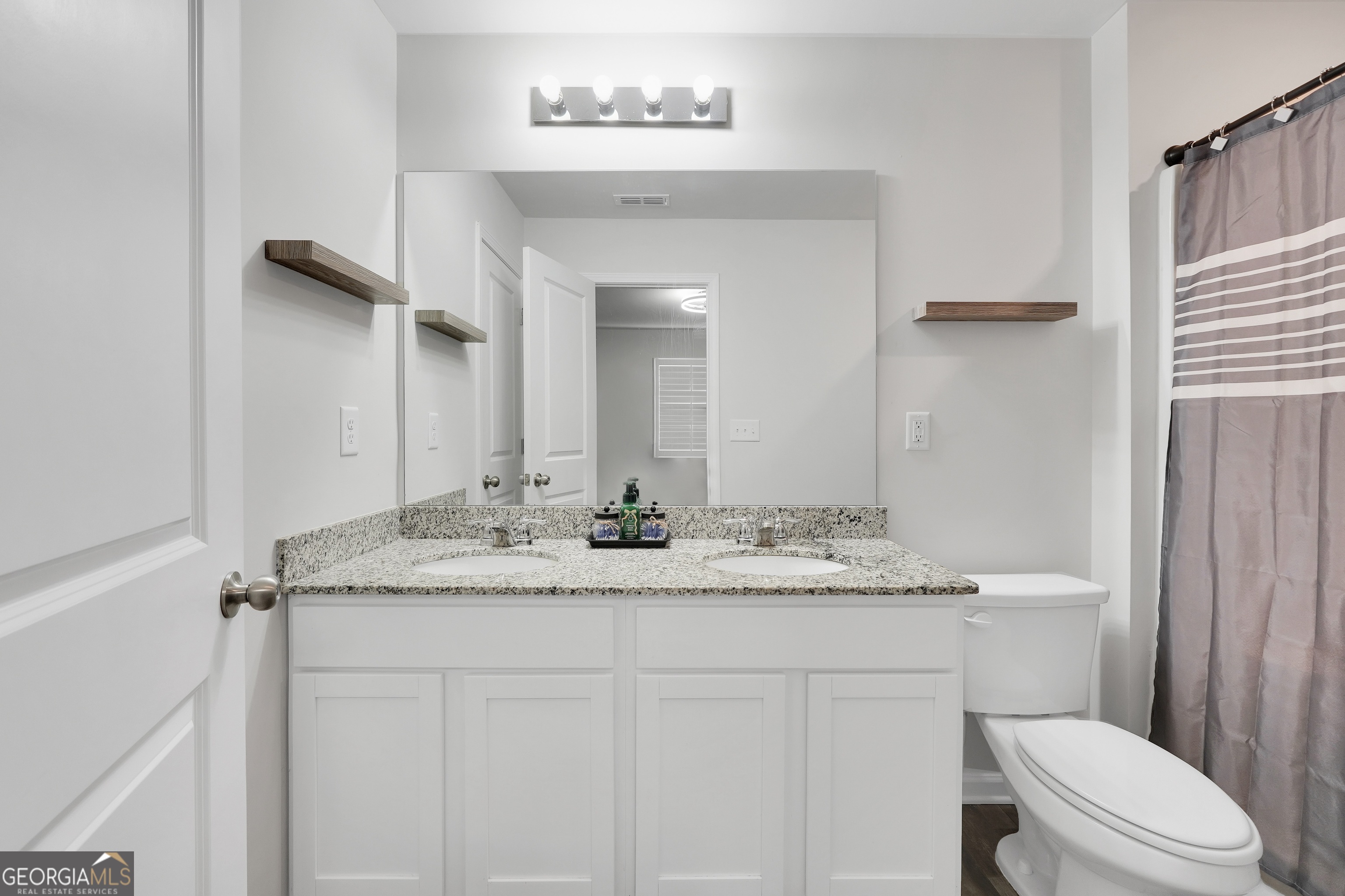 140 Catalpa Road Milner, GA 30257 - Photo 22 of 32 a bathroom with a granite countertop sink vanity mirror and toilet