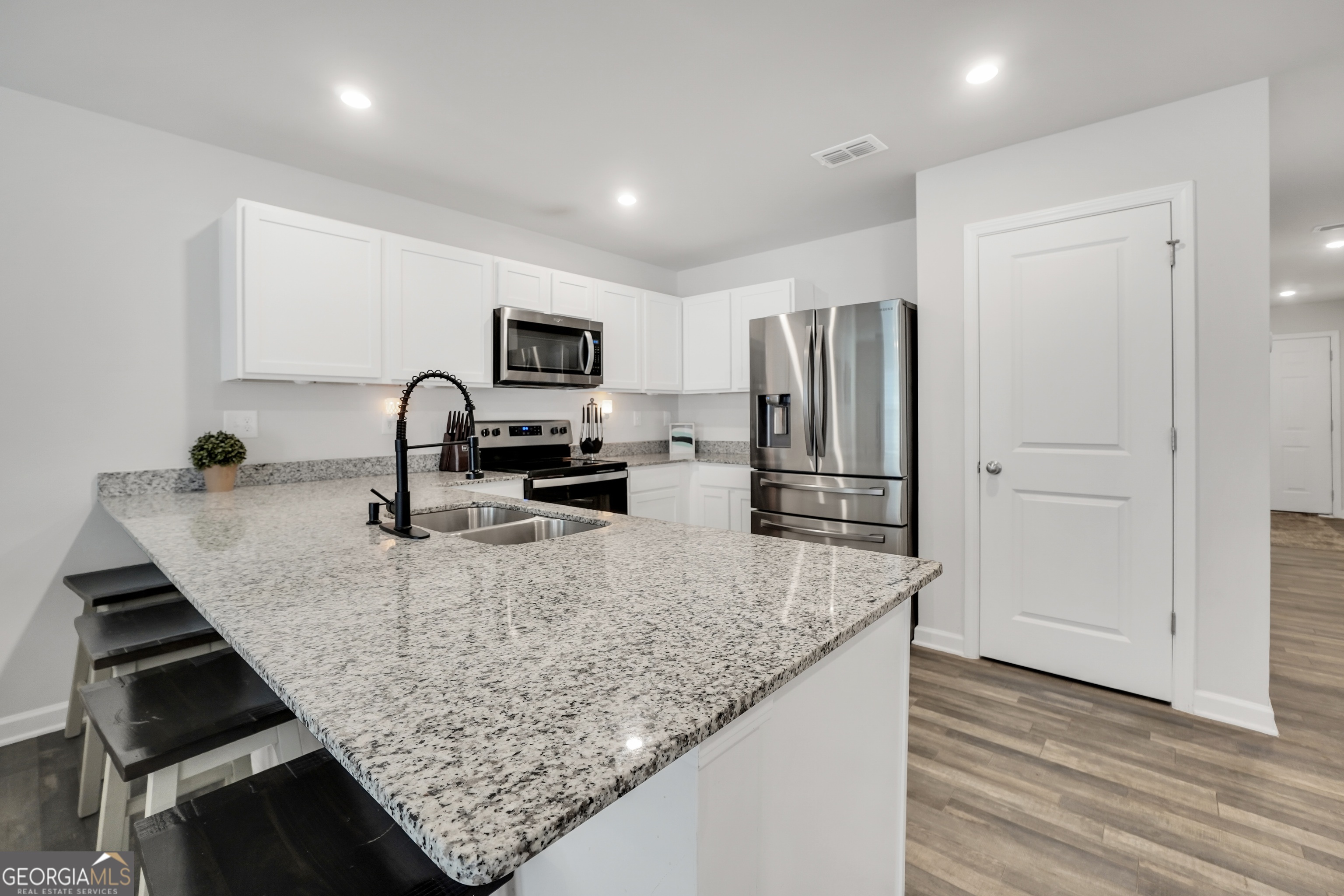 140 Catalpa Road Milner, GA 30257 - Photo 8 of 32 a kitchen with granite countertop a refrigerator and a sink