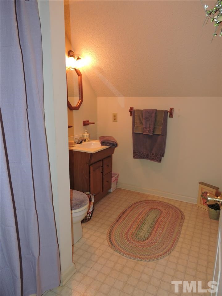 250 Kiser Hicks Road Roxboro, NC 27574 - Photo 15 of 19 a bathroom with a sink and mirror with bathtub