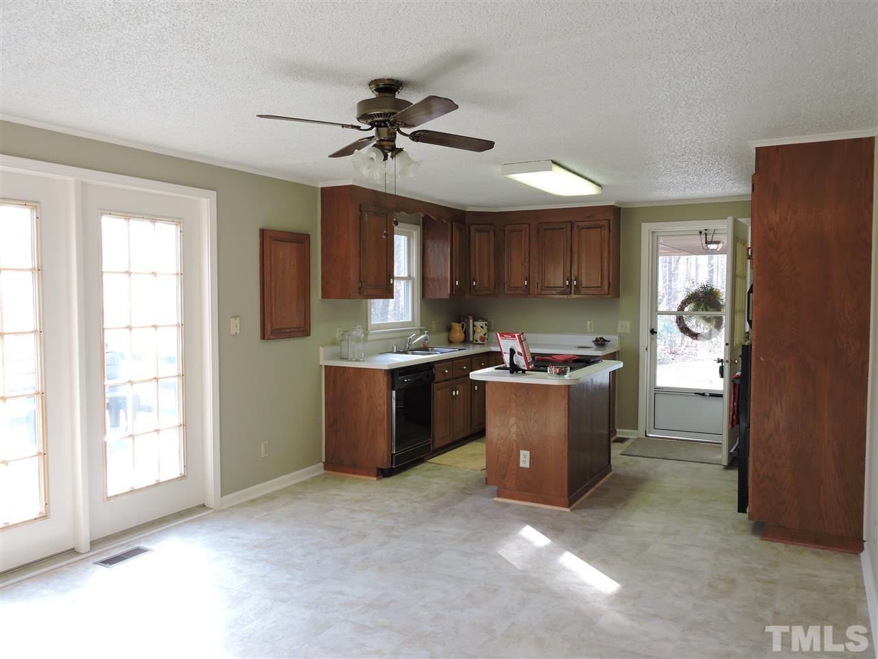 250 Kiser Hicks Road Roxboro, NC 27574 - Photo 5 of 19 a kitchen with a refrigerator a sink and dishwasher with wooden cabinets