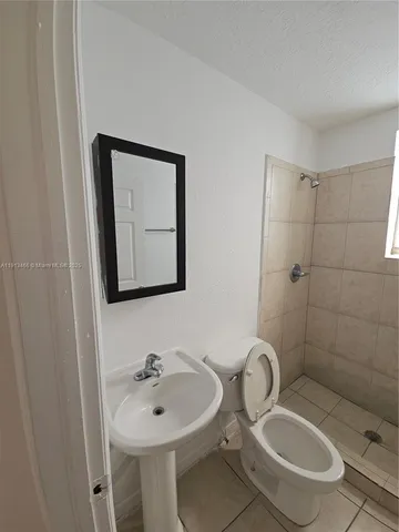a bathroom with a sink a toilet and mirror