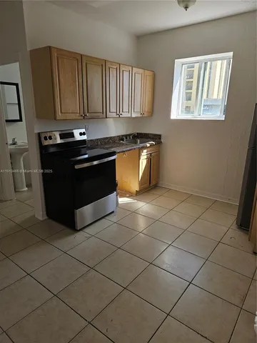 a kitchen with granite countertop a stove a sink and a microwave