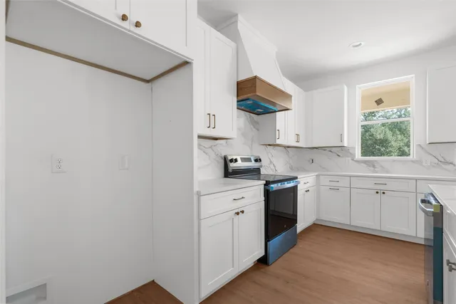 a kitchen with white cabinets and white appliances