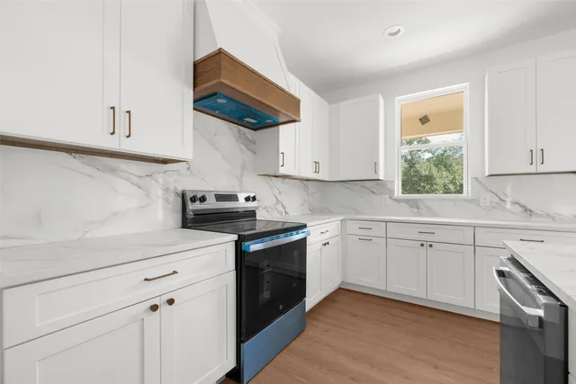 a kitchen with white cabinets stainless steel appliances and sink