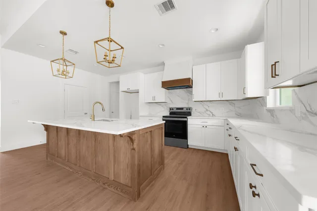 a kitchen with a sink a stove oven a counter space and cabinets