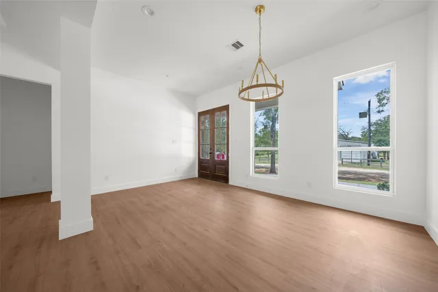 a view of a room with wooden floor fireplace and windows