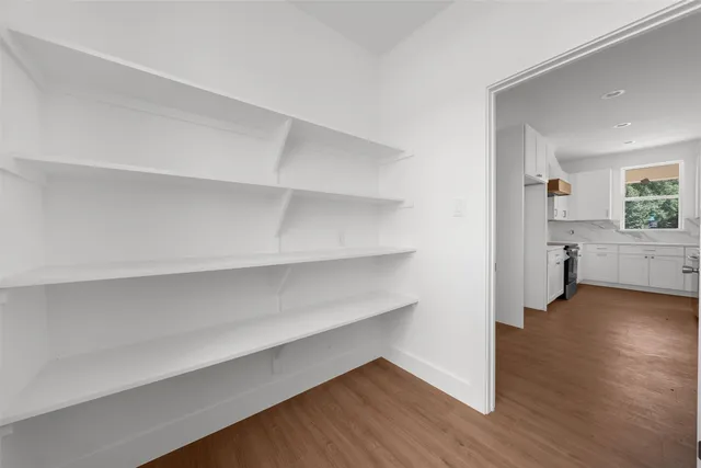 a view of a room with wooden floor and a bathroom