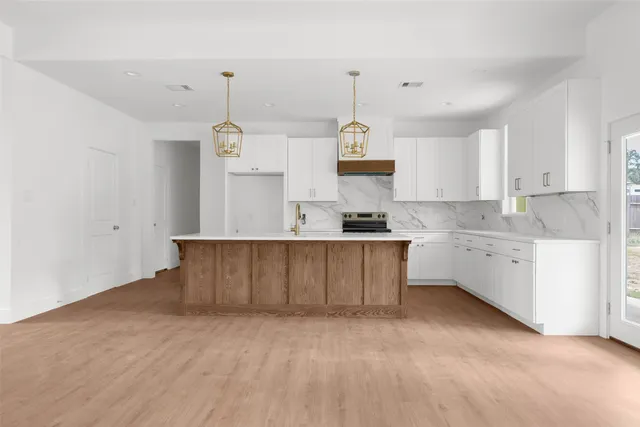a kitchen with kitchen island a stove a sink a center island and cabinets