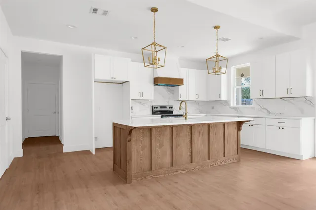 a kitchen with white cabinets and window