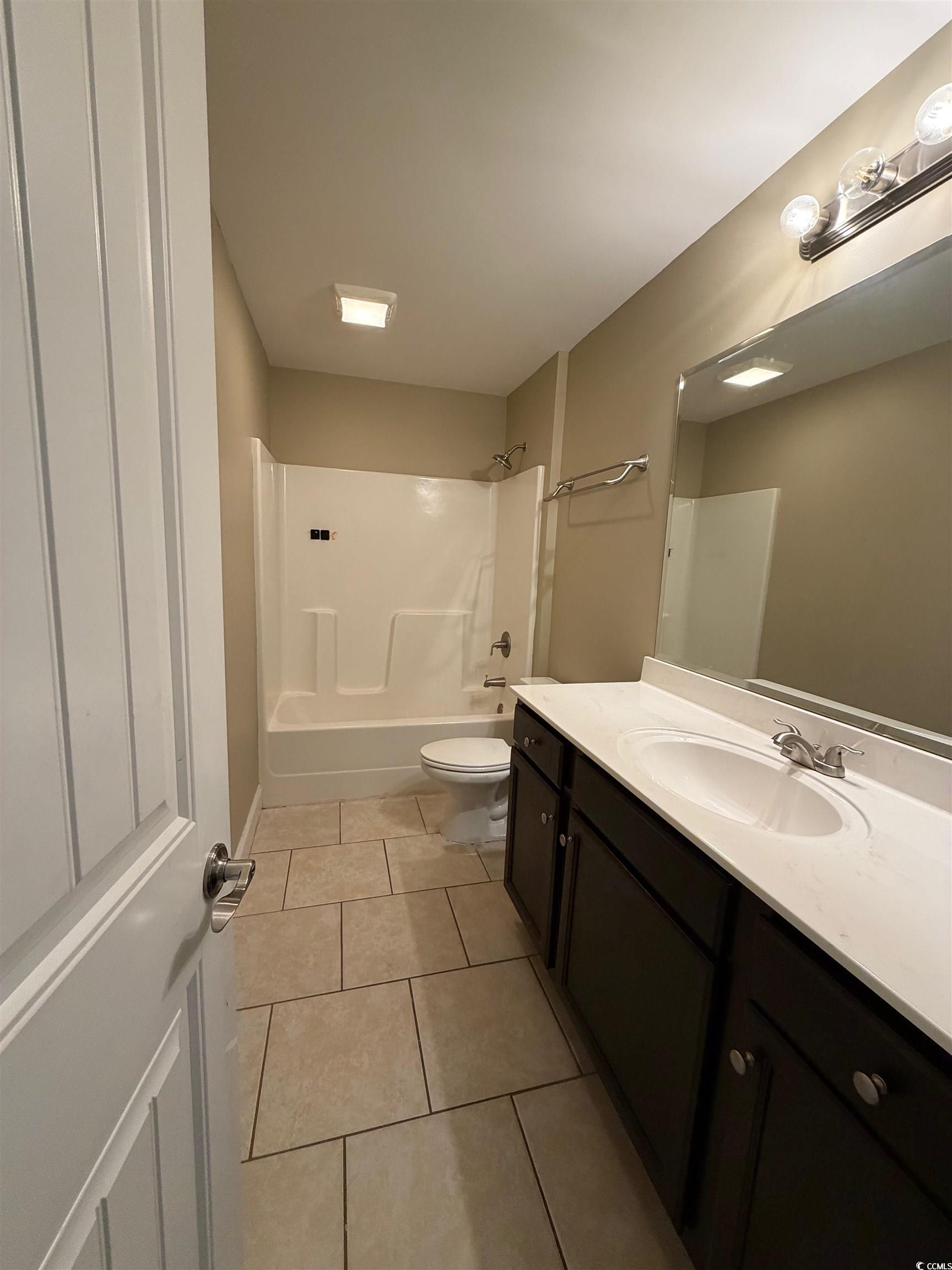 619 Uniola Drive Myrtle Beach, SC 29579 - Photo 15 of 22 Full bath featuring vanity, light tile patterned floors, and shower combination