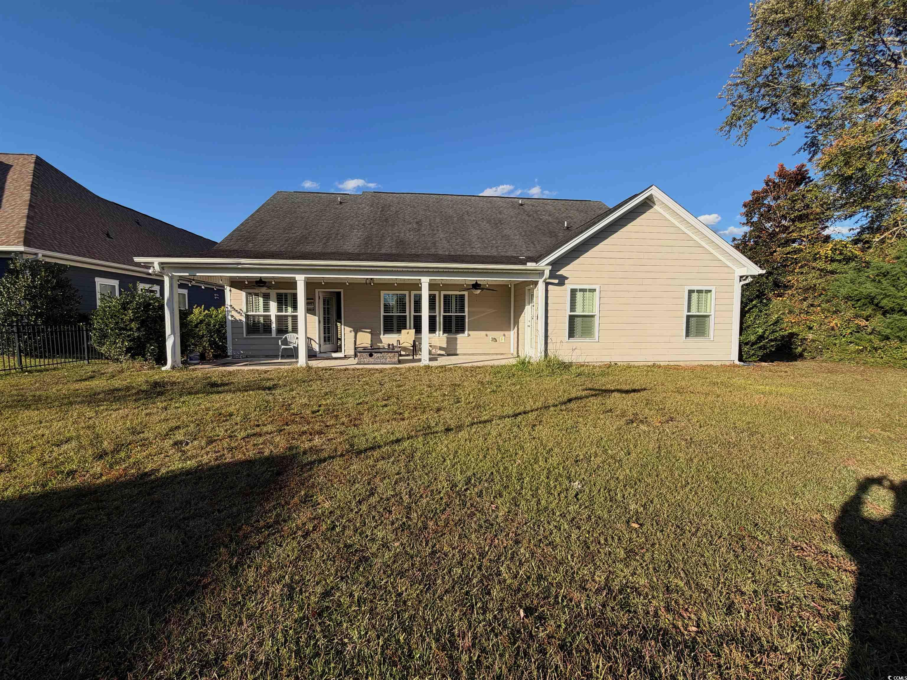 619 Uniola Drive Myrtle Beach, SC 29579 - Photo 21 of 22 Back of property featuring ceiling fan, a patio area, and a yard