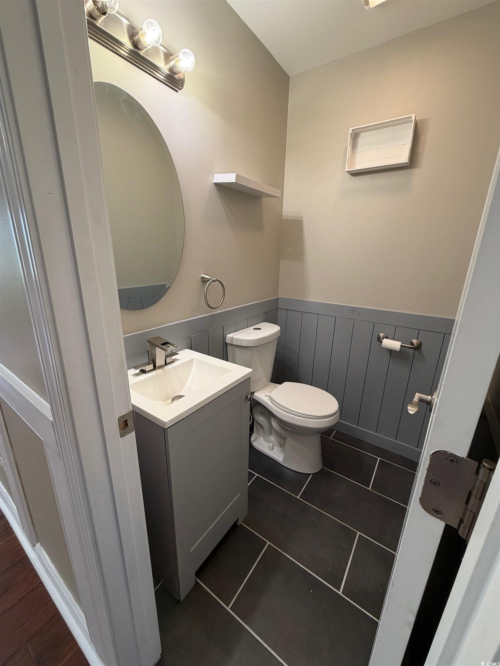 619 Uniola Drive Myrtle Beach, SC 29579 - Photo 5 of 22 Bathroom with vanity, dark tile patterned floors, and wainscoting