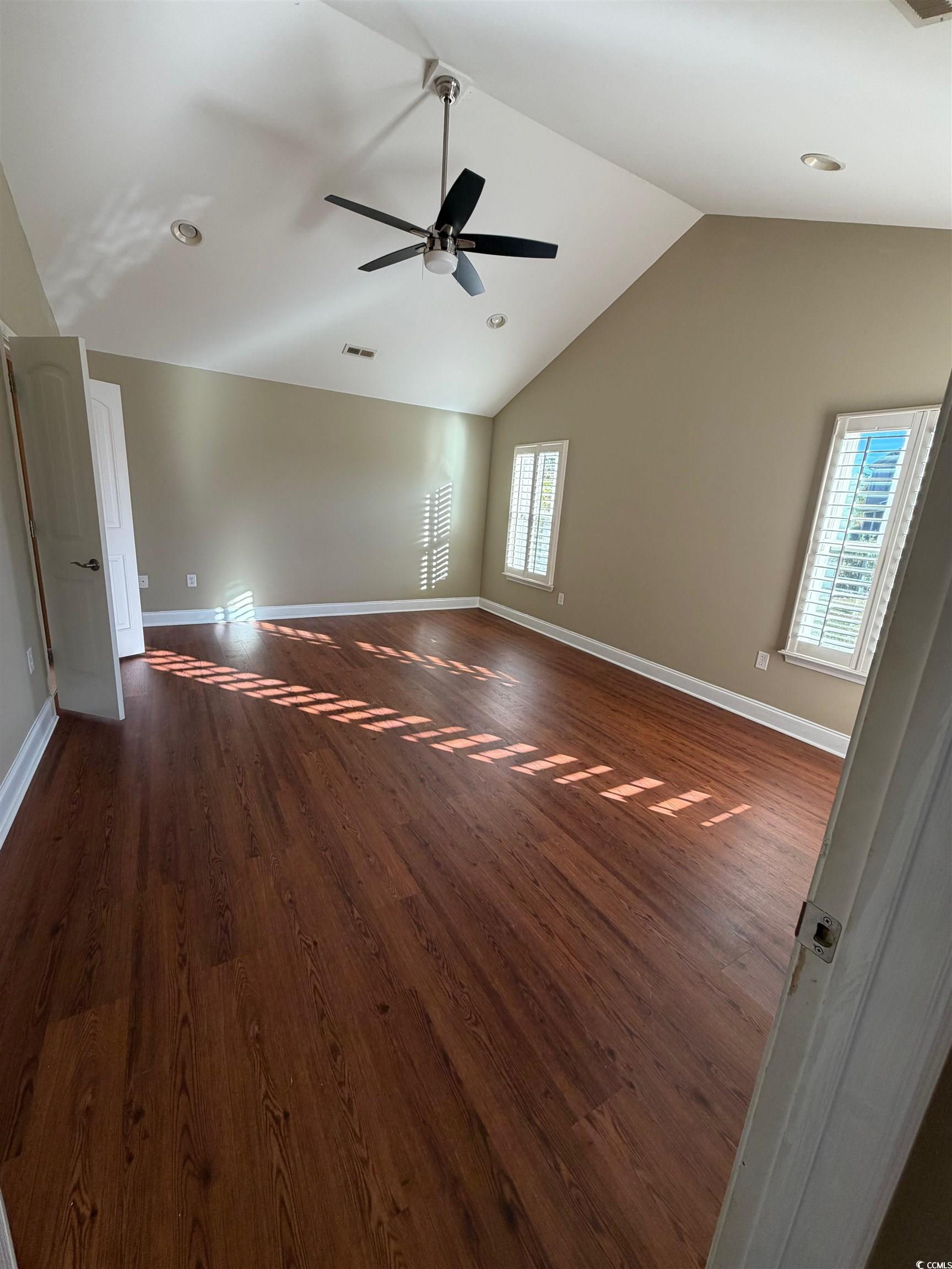619 Uniola Drive Myrtle Beach, SC 29579 - Photo 8 of 22 Unfurnished room featuring lofted ceiling, dark wood finished floors, and ceiling fan