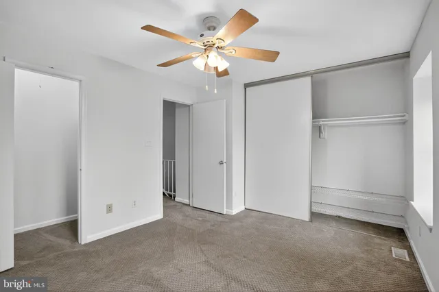 a view of an empty room with a ceiling fan