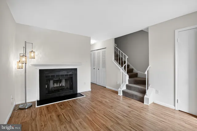 a view of empty room with fireplace and wooden floor