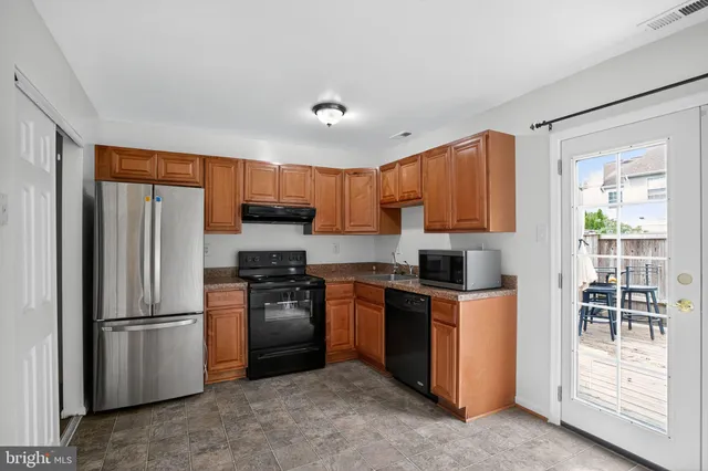 a kitchen with stainless steel appliances granite countertop a refrigerator stove and sink