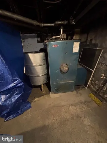 a room with water heater and wooden cabinets