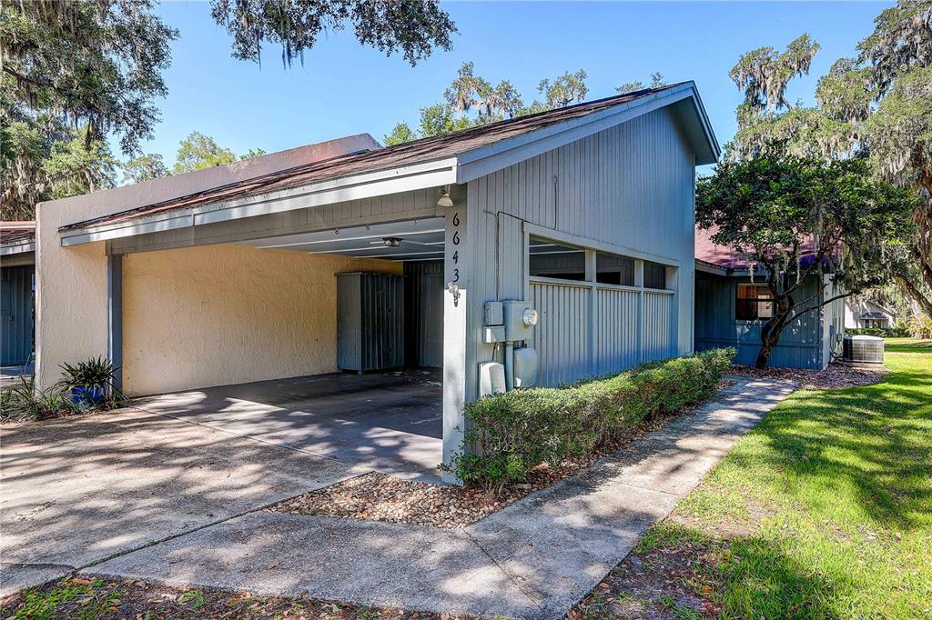 6643 Trail Ridge Drive Lakeland, FL 33813 - Photo 3 of 36 a view of a house with a small yard and a large tree