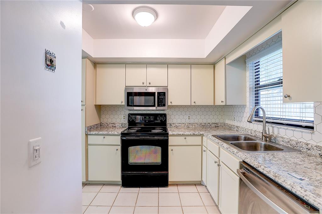6643 Trail Ridge Drive Lakeland, FL 33813 - Photo 5 of 36 a kitchen with stainless steel appliances granite countertop a sink stove and microwave