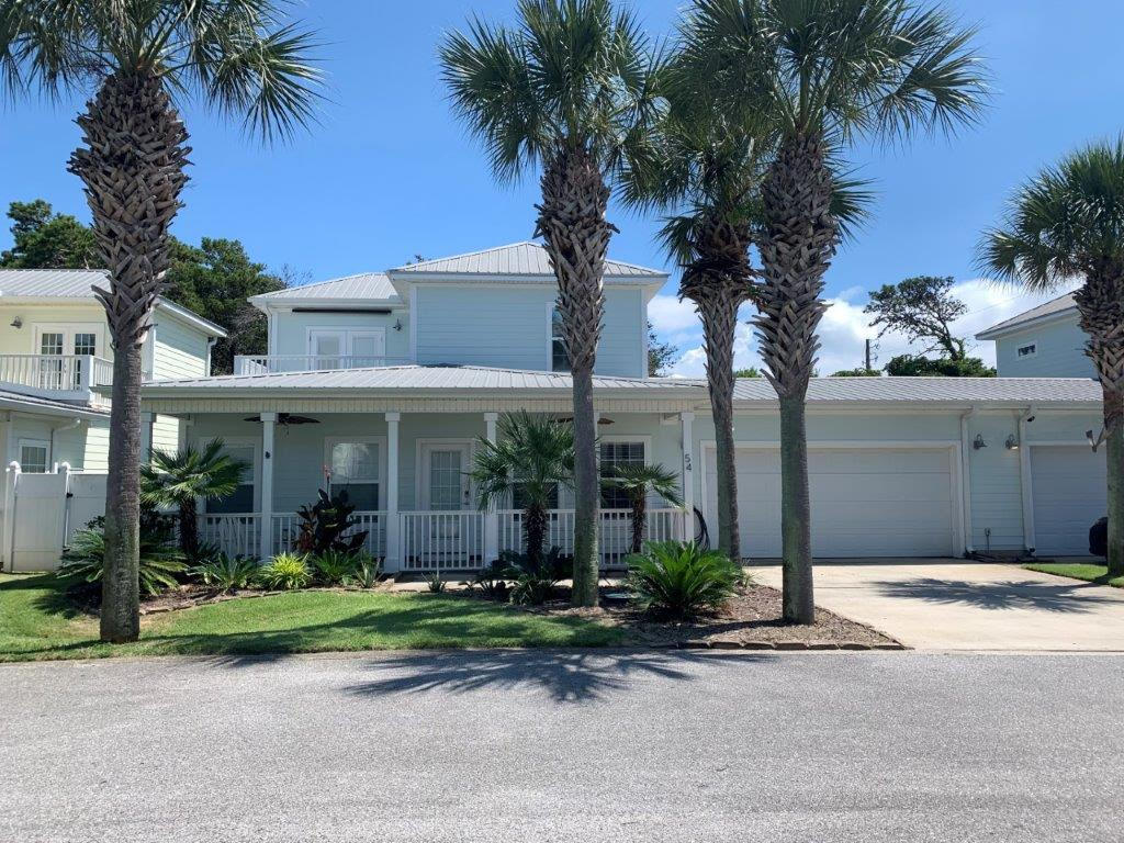 a front view of a house with plants and trees