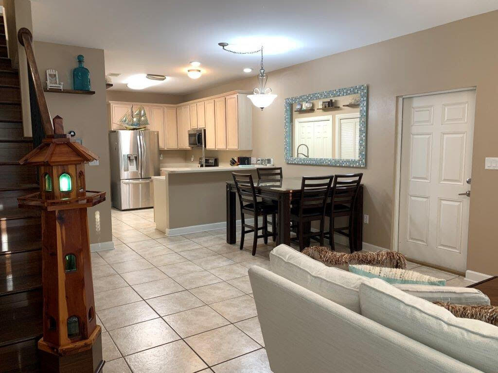 54 Batchelors Button Drive, Unit 9 Miramar Beach, FL 32550 - Photo 24 of 28 a living room with couches a dining table and kitchen view with wooden floor