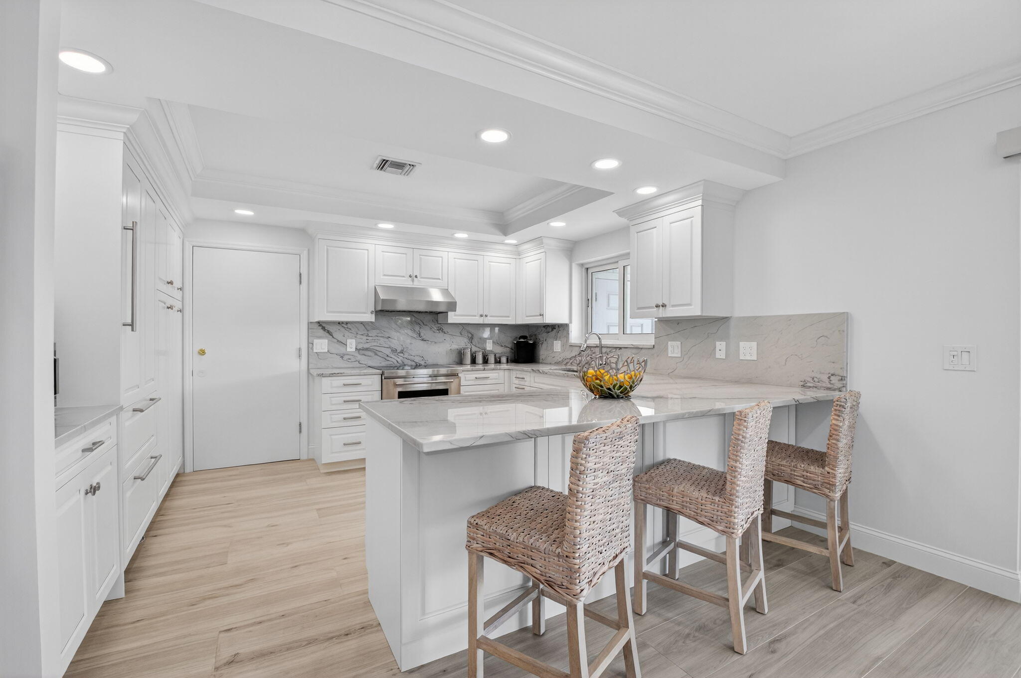1710 South Ocean Boulevard, Unit 32 Delray Beach, FL 33483 - Photo 14 of 58 a kitchen with a dining table chairs wooden cabinets and white stainless steel appliances