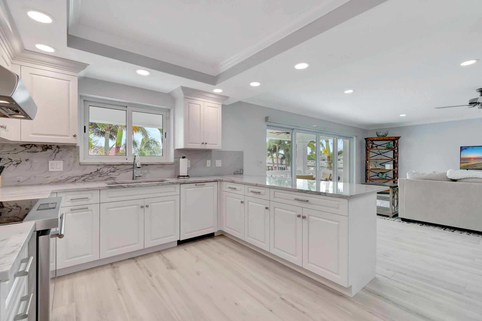 1710 South Ocean Boulevard, Unit 32 Delray Beach, FL 33483 - Photo 20 of 58 a large kitchen with granite countertop a stove a sink a window and white cabinets