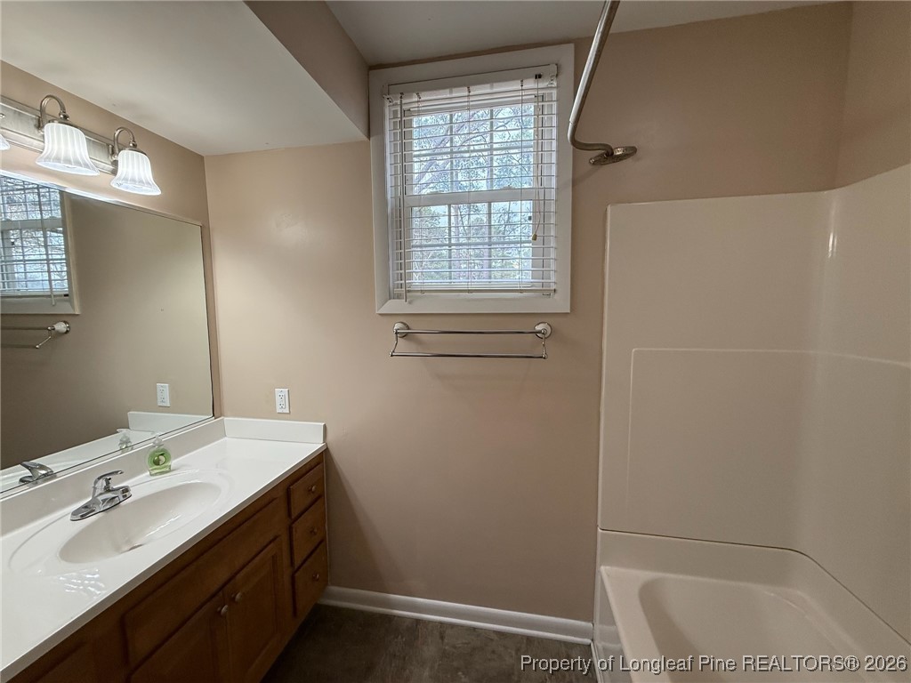 161 Fowler Lane Dunn, NC 28334 - Photo 9 of 12 a bathroom with a tub sink and mirror