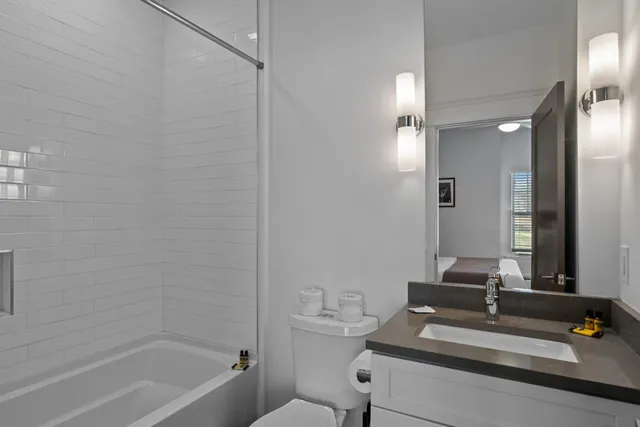 a bathroom with a tub sink vanity and a mirror