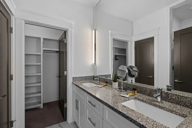 a bathroom with a granite countertop sink and a mirror
