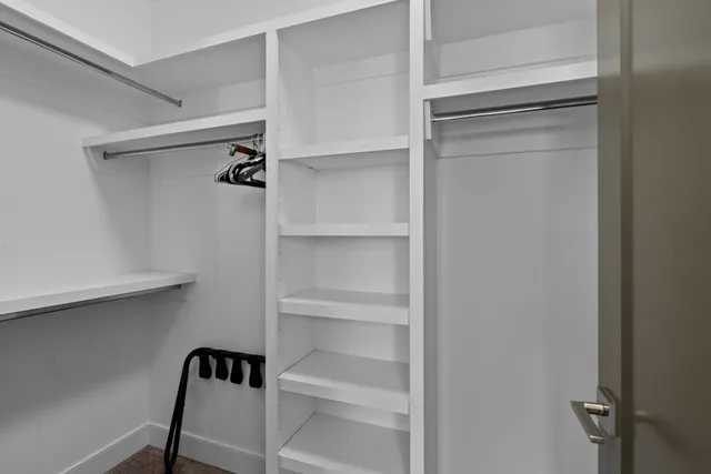 a view of walk in closet with empty racks