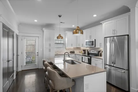 a kitchen with stainless steel appliances a refrigerator sink and stove