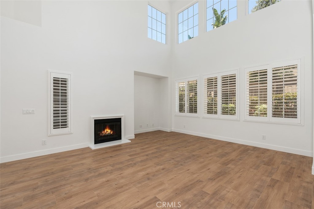 a view of an empty room with a window and fireplace