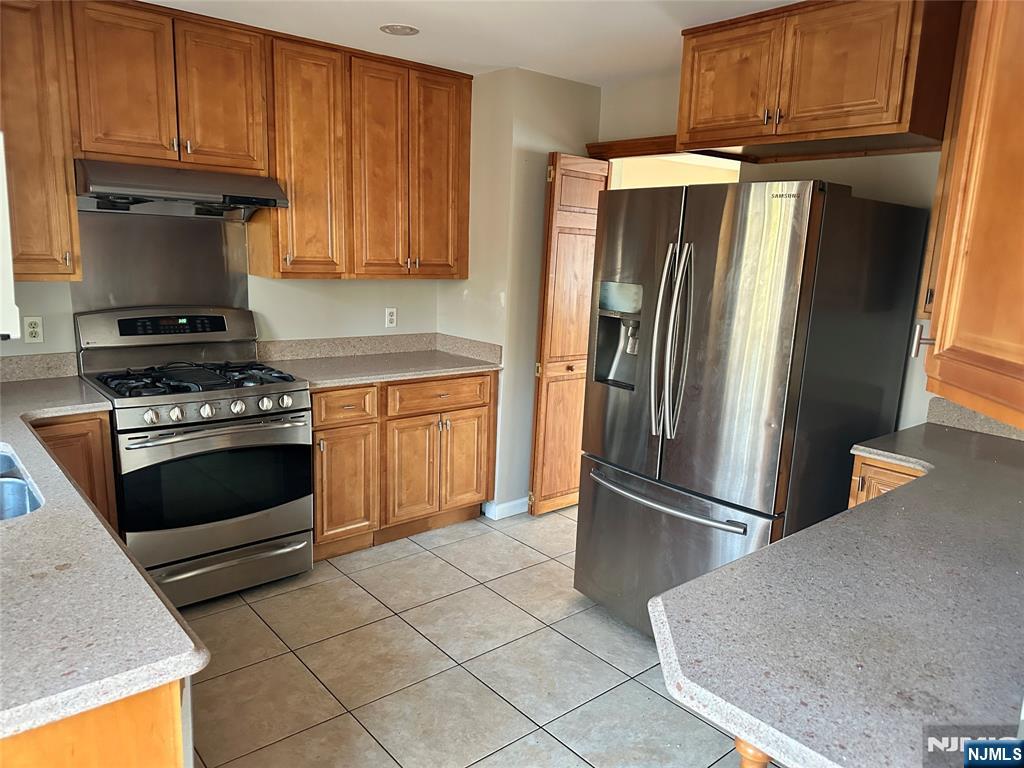 718 Spring Avenue Ridgewood, NJ 07450 - Photo 5 of 20 a kitchen with granite countertop a refrigerator stove and cabinets