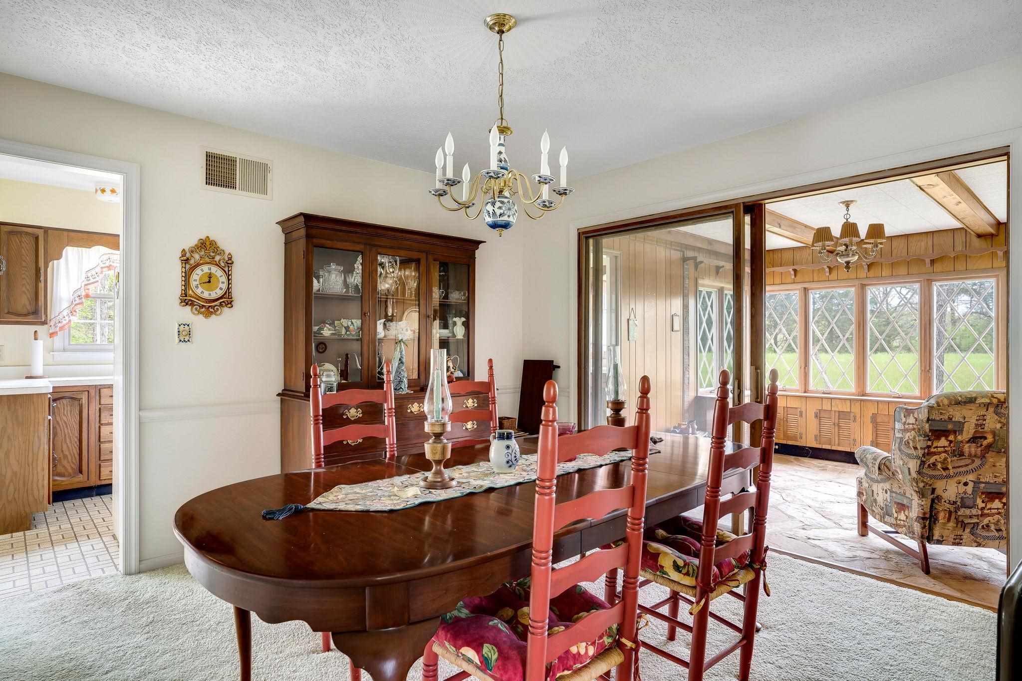 11590 Fort Valley Road Fort Valley, VA 22652 - Photo 14 of 40 a dining room with furniture a chandelier and wooden floor