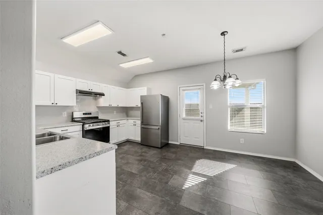 a kitchen with stainless steel appliances granite countertop a sink a stove a refrigerator and island