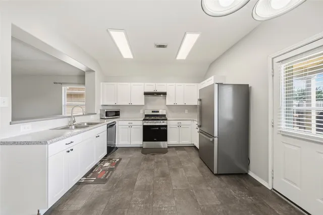 a kitchen with a white cabinets and white stainless steel appliances