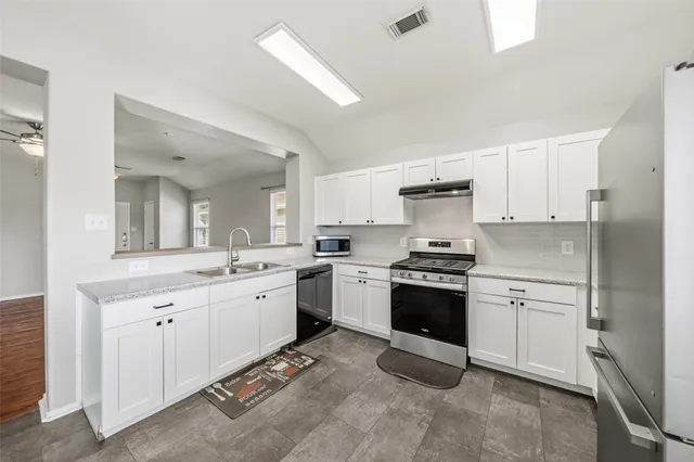 a large kitchen with a stove top oven and cabinets