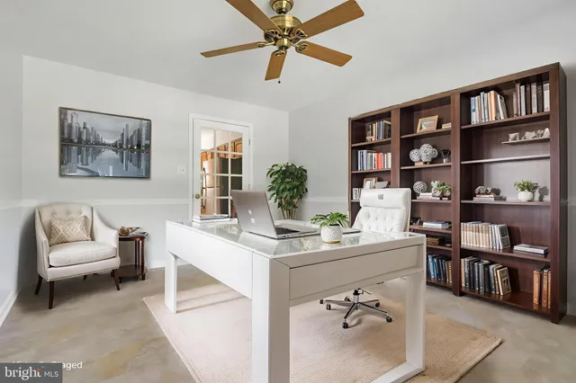a living room with furniture a rug and a book shelf