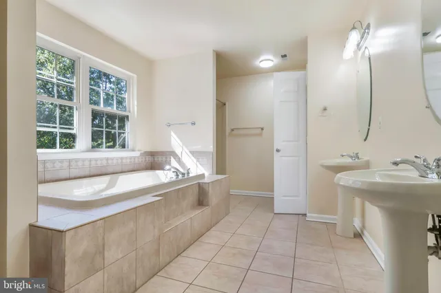 a bathroom with a granite countertop sink and a bathtub