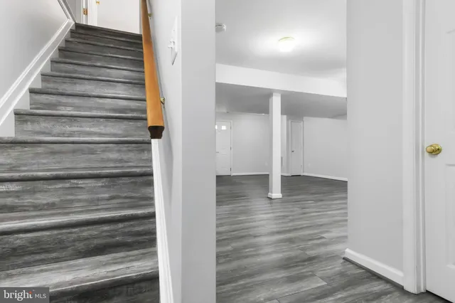 an empty room with wooden floor ceiling fan