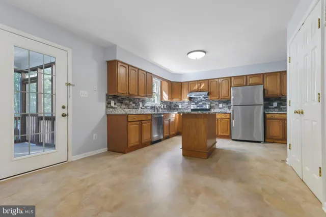 a kitchen with a refrigerator and a stove top oven