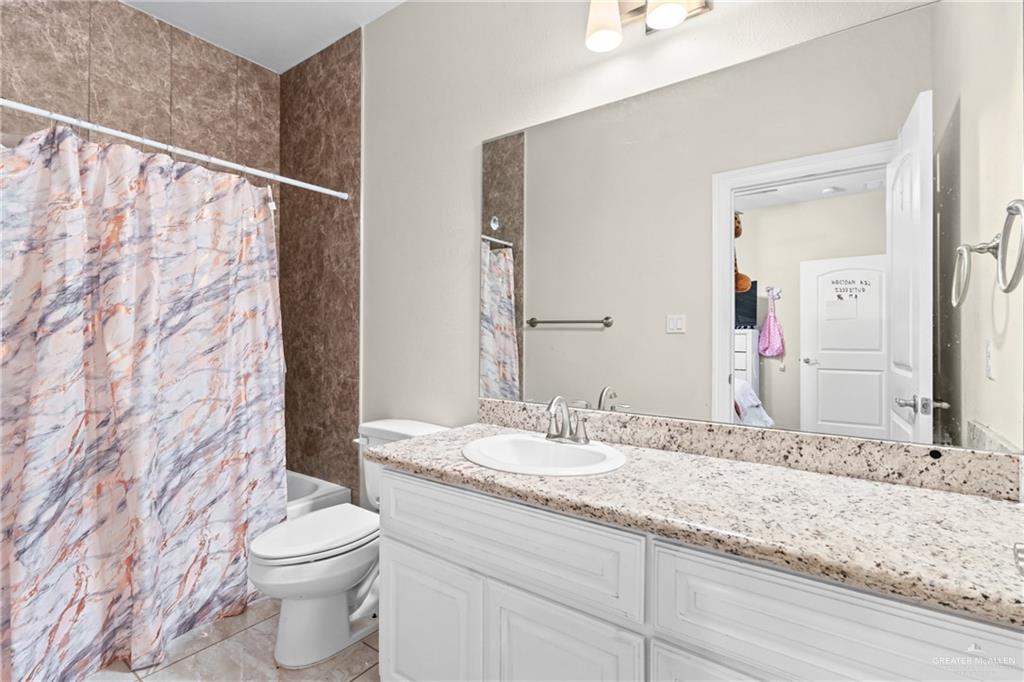 1904 Ridgeway Circle Edinburg, TX 78542 - Photo 21 of 32 Bathroom featuring a white vanity with paneling, a light-toned granite countertop, and an undermount sink