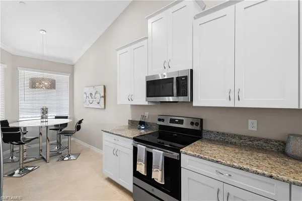 a kitchen with stainless steel appliances granite countertop a stove a sink and a microwave