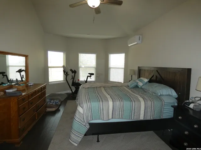 a bedroom with a bed and dresser with mirror