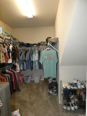 a view of walk in closet with clothes and shoes