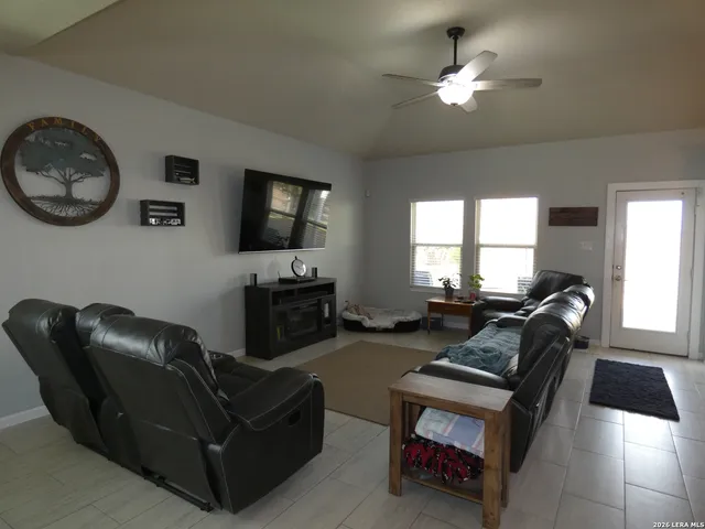 a living room with furniture a flat screen tv and a window